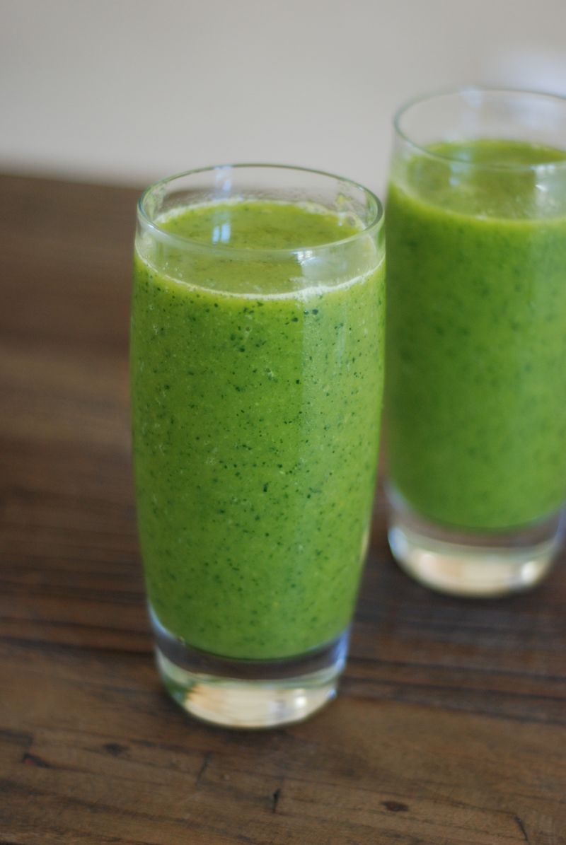 Två glas grön smoothie på ett träbord
